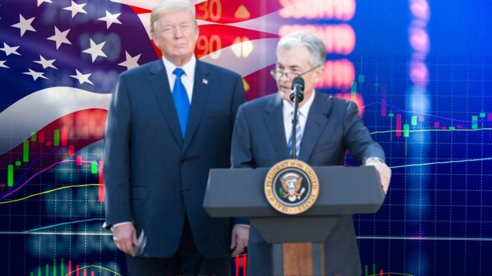 Em um fundo com a bandeira dos EUA e gráfico da bolsa, o presidente do Fed, Jerome Powell, está de pé em frente a um púlpito. Ele veste terno azul marinho. Atrás dele, está Donald Trump, também vestindo terno azul marinho.