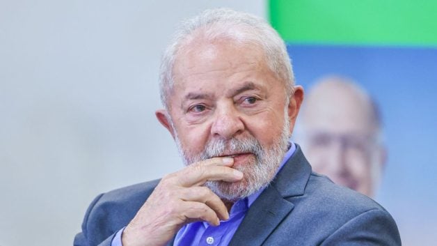 Lula de terno azul, com as mãos na boca